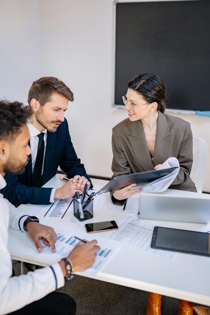 Three professionals engaged in a productive office meeting sharing ideas and discussing strategies.